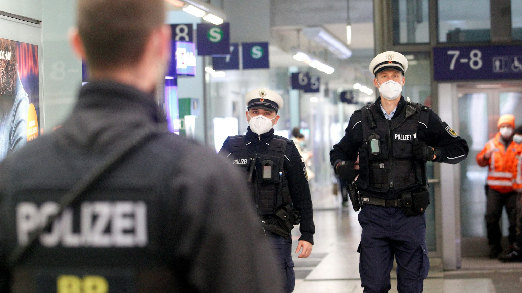 Beamte der Bundespolizei laufen im Bahnhofsgebäude Streife.