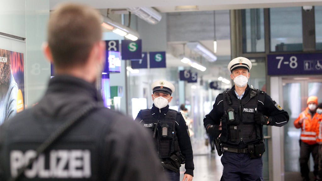 Beamte der Bundespolizei laufen im Bahnhofsgebäude Streife.