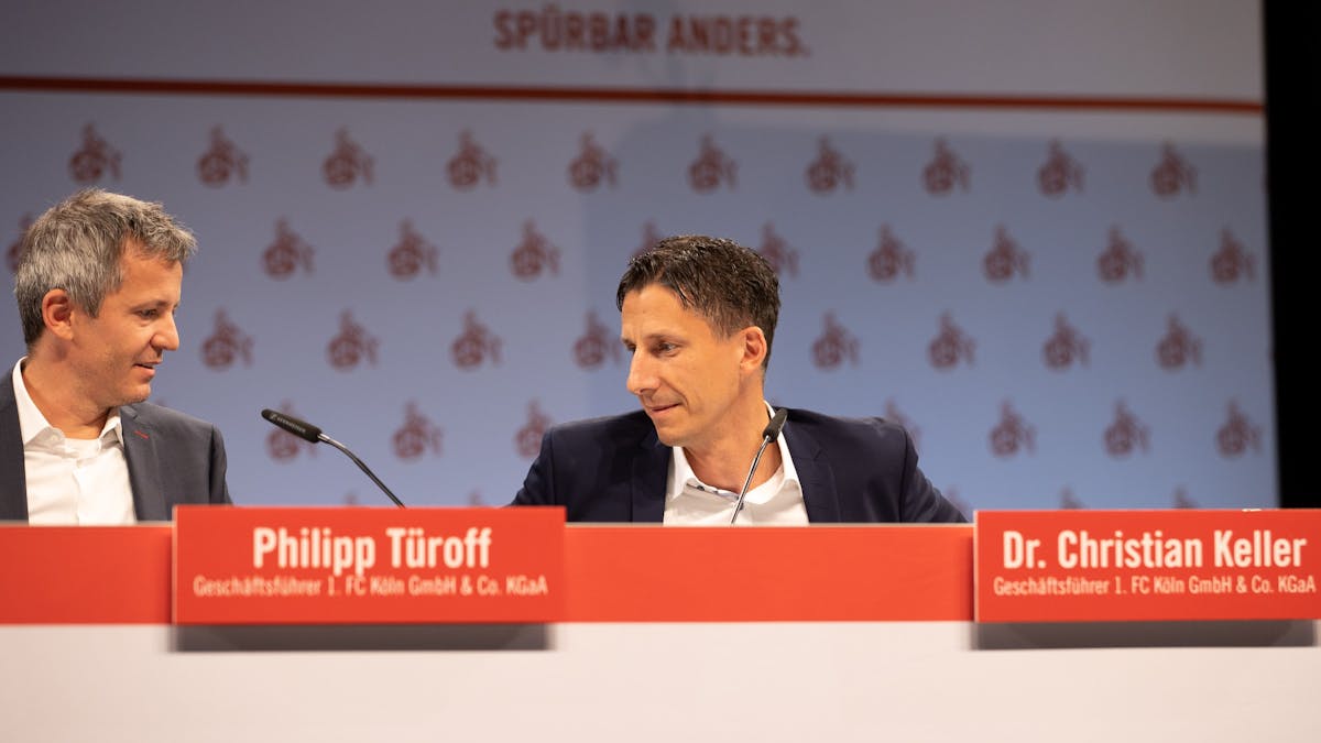 Philipp Türoff und Christian Keller sitzen bei der Mitgliederverammlung des 1. FC Köln auf dem Podium.