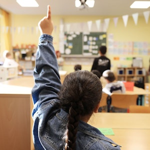 Eine Schülerin zeigt in der Grundschule Feldstraße im Unterricht auf.