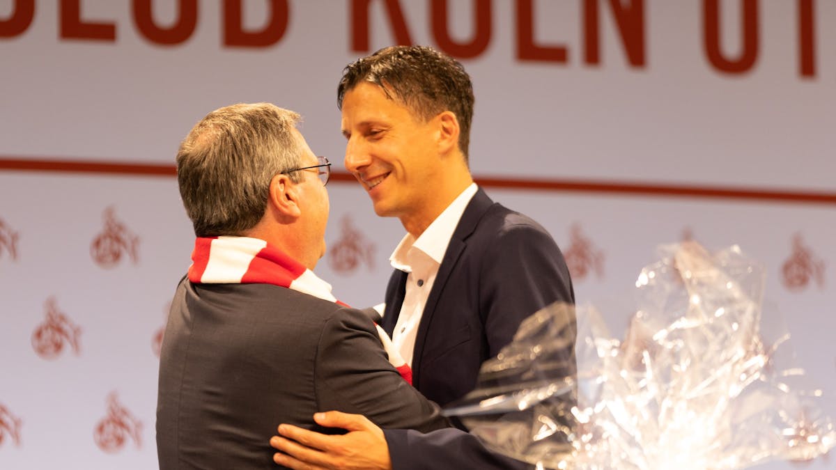 Dr. Werner Wolf (Vorstand) und Dr. Christian Keller (Geschäftsführer 1. FC Köln) umarmen sich bei der Mitgliederversammlung des 1. FC Köln.