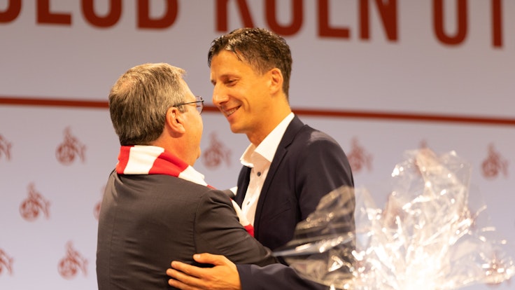 Dr. Werner Wolf (Vorstand) und Dr. Christian Keller (Geschäftsführer 1. FC Köln) umarmen sich bei der Mitgliederversammlung des 1. FC Köln.