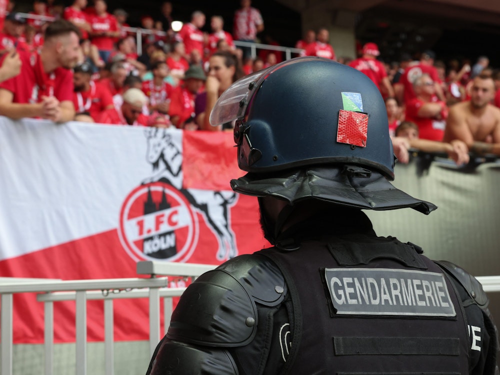 Ein französischer Polizist steht beim Conference-League-Spiel vor dem Block der Gäste-Fans des 1. FC Köln.