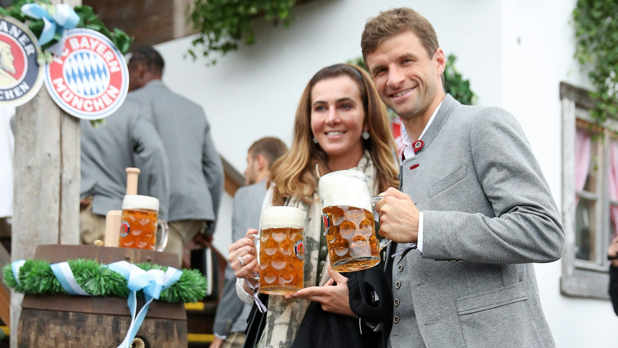 Thomas und seine Frau posieren mit Bierkrügen für die Kameras.