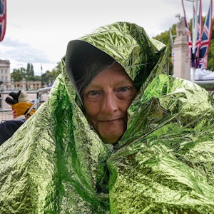 Caryll Foster hält sich mit einer Rettungsdecke warm, da sie über Nacht bleiben wird, um in der ersten Reihe bei den Trauerfeierlichkeiten der Königin in der Mall vor dem Buckingham Palace sitzen will.