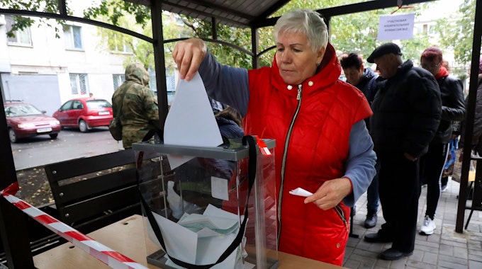 Eine Frau stimmt am Freitag (23. September) während des Scheinreferendums in einem mobilen Wahllokal in Mariupol in der von den von Russland unterstützten Separatisten kontrollierten Volksrepublik Donezk im Osten der Ukraine ab.