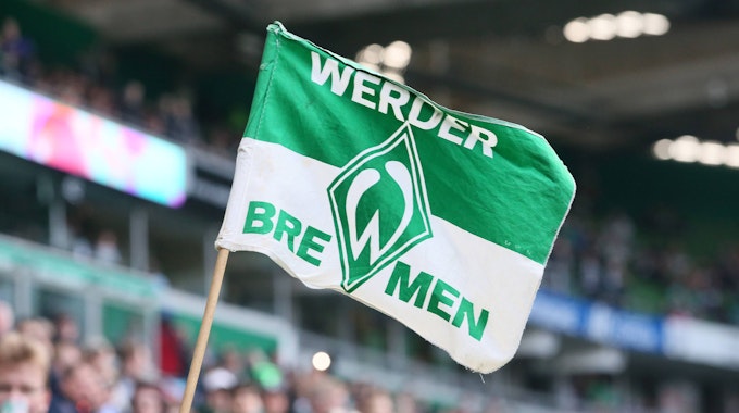 Das Bild zeigt eine kleine Fahne mit dem Werder-Bremen-Wappen darauf.