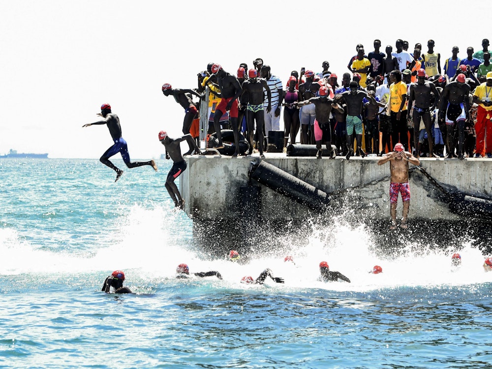TOPSHOT - Competitors take the start of the circuit A of the swimming race from Dakar to Goree on September 25, 2022 in Dakar. (Photo by SEYLLOU / AFP)