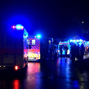 Rettungswagen und Einsatzfahrzeuge der Polizei stehen in der Nacht auf der Straße.