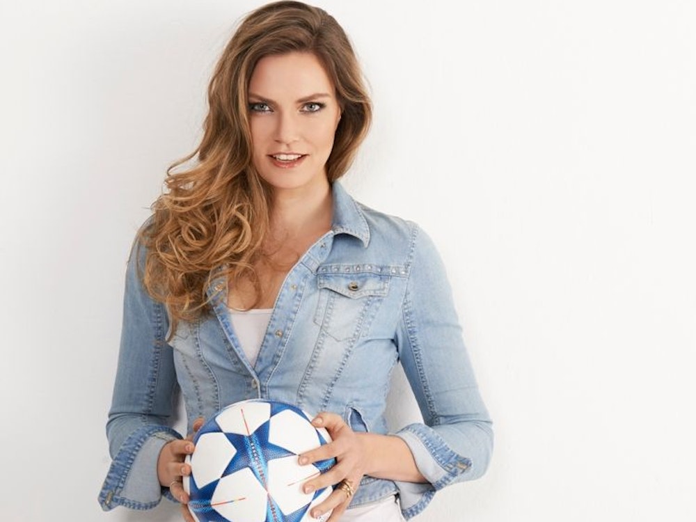 ARD-Moderatorin Julia Scharf hat einen Fußball in der Hand.