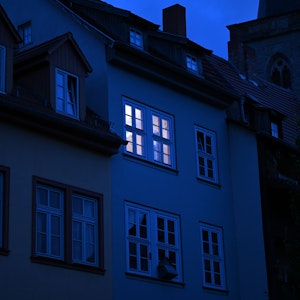 Dieses undatierte Symbolbild zeigt ein hell erleuchtetes Wohnungsfenster im Morgengrauen.
