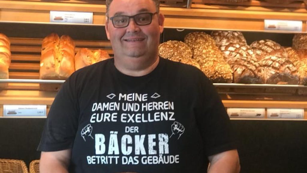 Bäcker Gudio Boveleth steht in seiner Bäckerei vor einem Brotregal.