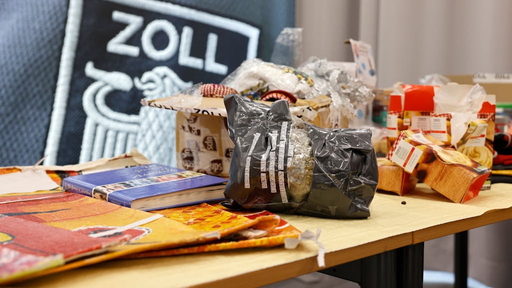 Auf einem Tisch im Zollamt Köln liegen diverse sichergestellte Drogen und deren Verpackungen, die als Verstecke genutzt wurden.