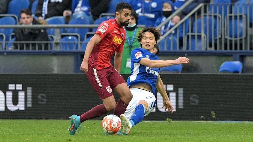 Regensburgs Sarpreet Singh (l) und Schalkes Ko Itakura kämpfen um den Ball.