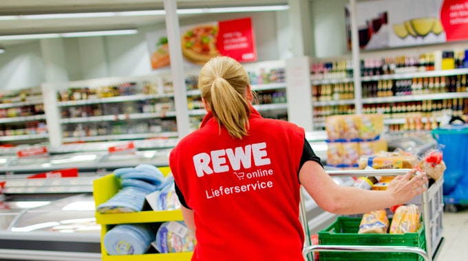 Bei Rewe müssen Kundinnen und Kunden einen Rückruf beachten. Unser Foto zeigt eine Mitarbeiterin in einer Rewe-Filiale.