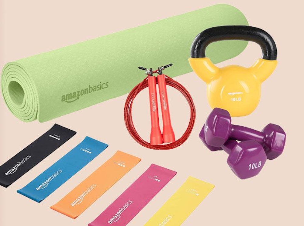Sportgeräte von Amazon Basics, grüne Yoga Matte, Fitnessbänder, lila Hanteln, rotes Springseil.