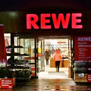 Rewe warnt vor dem Verzehr eines Tiefkühl-Produkts. Das Foto zeigt den Eingangsbereich einer Rewe-Filiale.