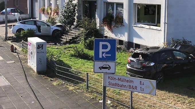 Zwei kaputte Autos liegen in einem Garten in Leverkusen-Schlebusch.