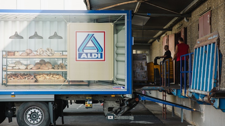 Mitarbeiter beladen einen Lastkraftwagen vor dem Logistikzentrum Aldi Nord: Aldi passt die Preise für einzelne Produkte an, sie werden nun wieder billiger.