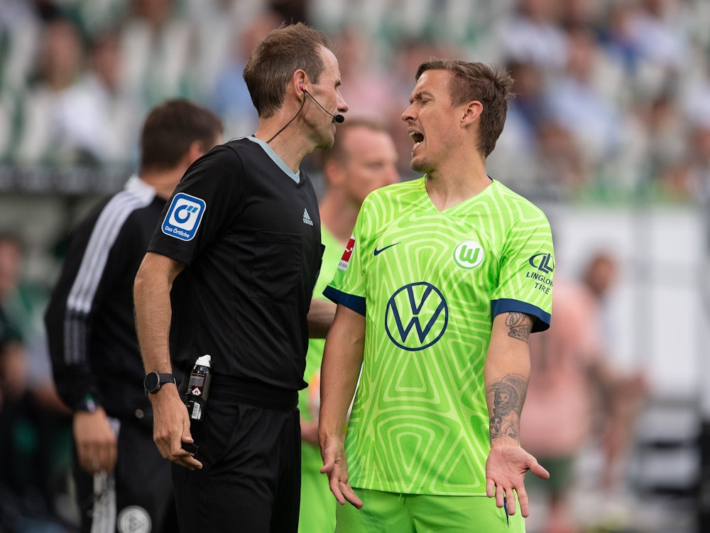 Wolfsburgs Max Kruse (r) diskutiert mit Schiedsrichter Sascha Stegemann.