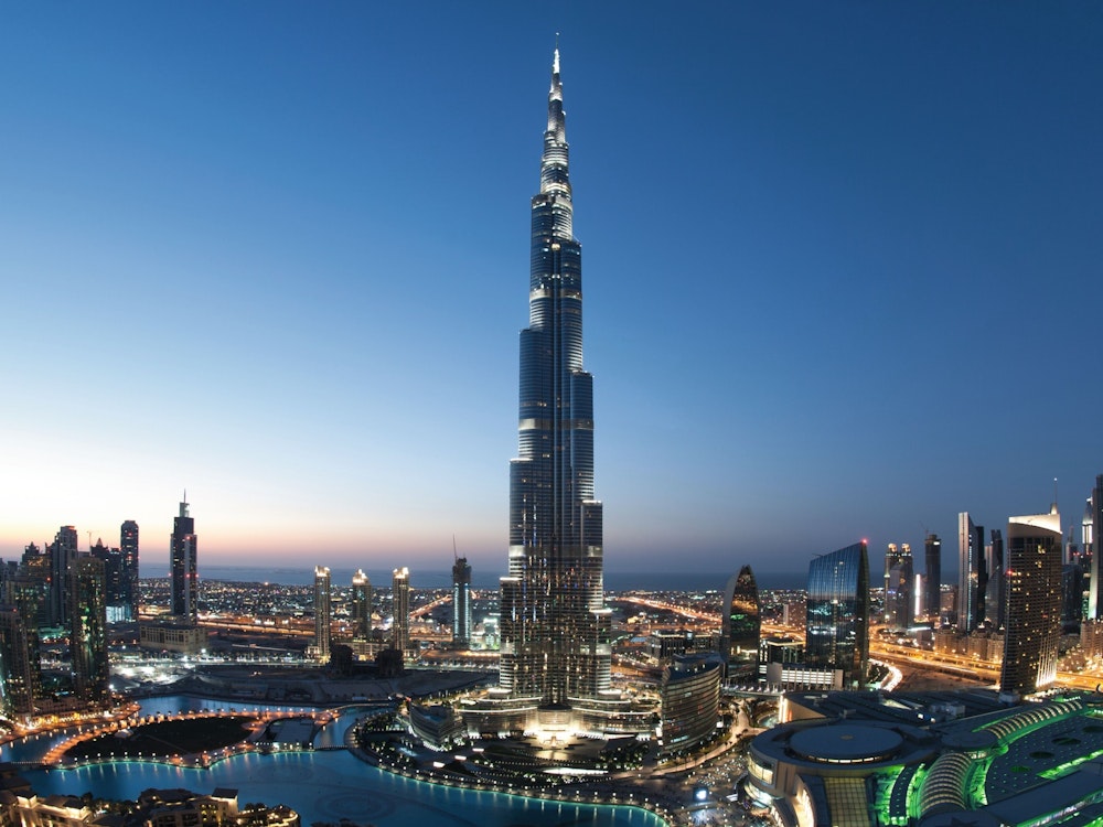 Der Burj Khalifa ist mit einer Höhe von unglaublichen 829,8 Metern das zurzeit höchste Gebäude der Welt. Der nadelförmige Turm ist hier inmitten der hell erleuchteten Stadtlandschaft von Dubai abgebildet.