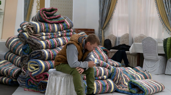 Ein russischer Mann ruht sich in einer provisorischen Unterkunft aus
