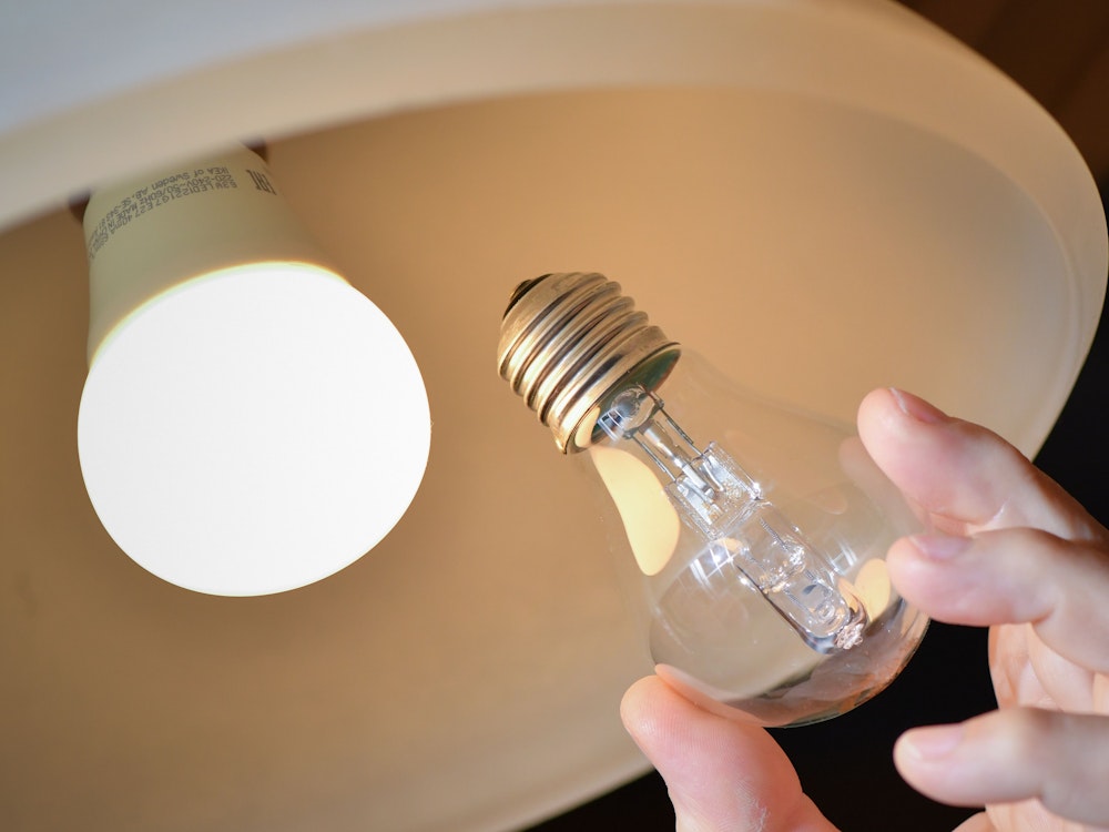An einer Deckenleuchte wird eine Halogenlampe (r) gegen eine energiesparende LED-Lampe ausgewechselt.
