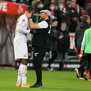 Anthony Modeste (l.) wird von 1. FC Köln-Trainer Steffen Baumgart (r.) am Rande eines Bundesligaspiels in den Arm genommen.