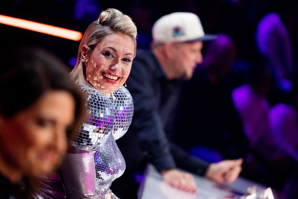 Ruth Moschner (M), Linda Zervakis and Smudo of the ratings team sit at the rates table for ProSieben's The Masked Singer.