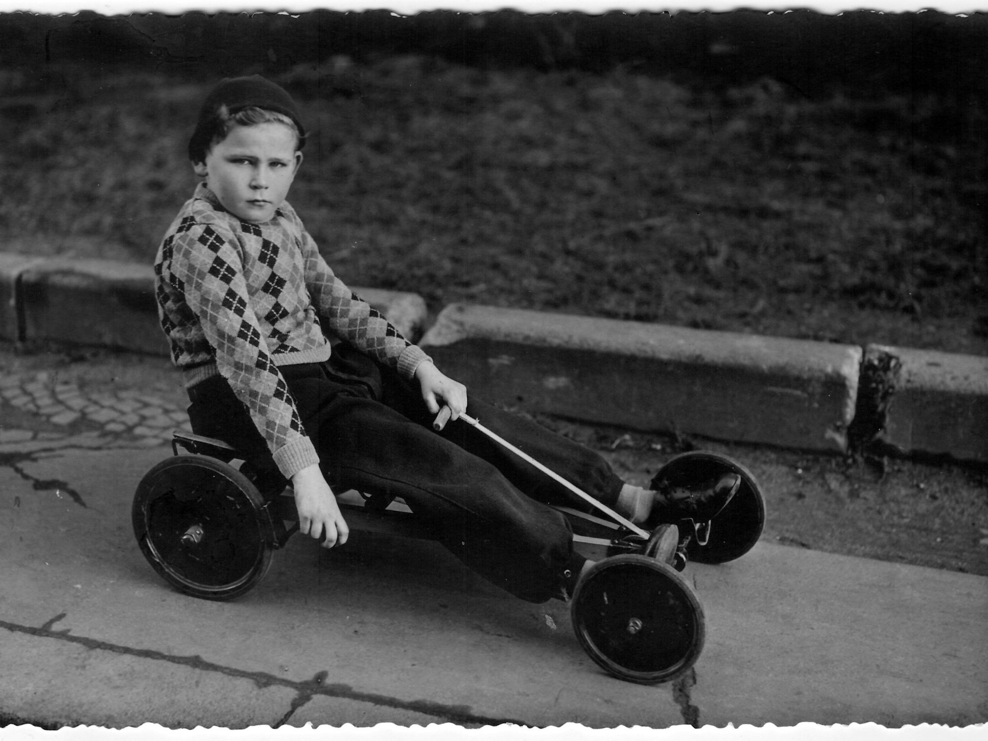 Günter Wallraff sitzt mit vier Jahren auf einem Kettcar.