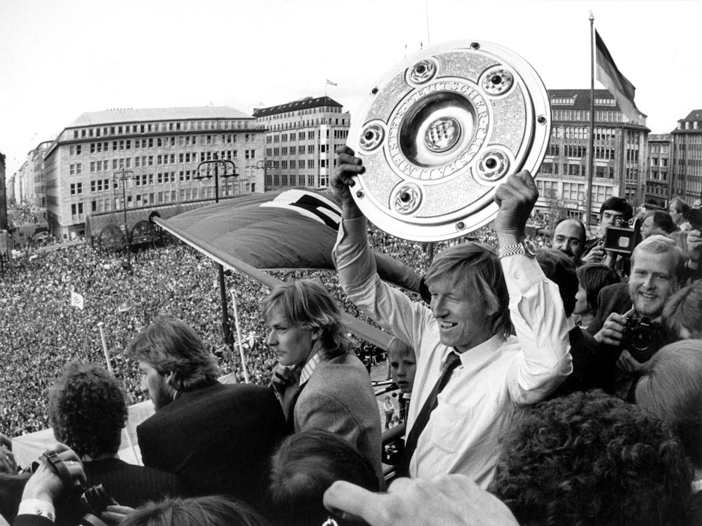 Hier feiert Horst Hrubesch vom Hamburger SV auf dem Hamburger Rathausbalkon mit Meisterschale und Fans am 29. Mai 1982