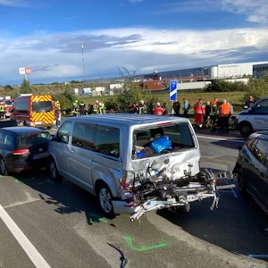 Unfallautos stehen auf der Autobahn A1. Im Hintergrund landet ein Hubschrauber.