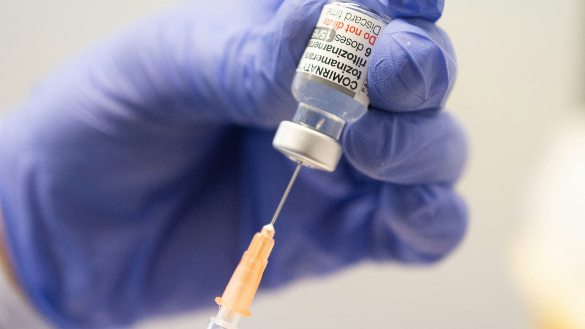 Ein Mitarbeiter zieht im Impfzentrum Mainz eine Spritze mit dem an die Omikron-BA.1-Variante angepassten Impfstoff Comirnaty von Biontech und Pfizer auf.