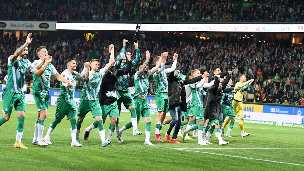 Werders Mannschaft feiert mit den Fans den Sieg.