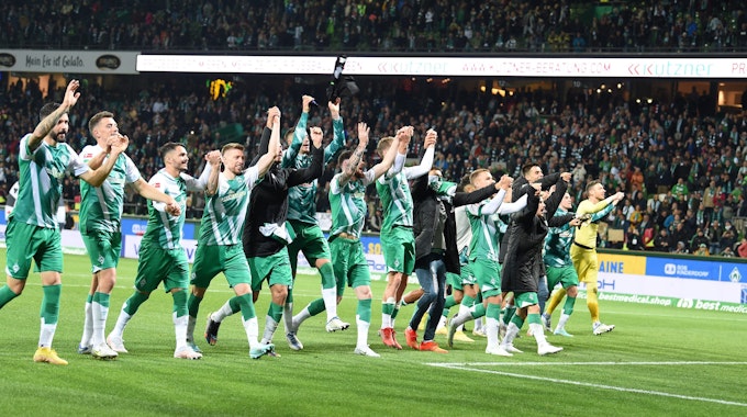 Werders Mannschaft feiert mit den Fans den Sieg.