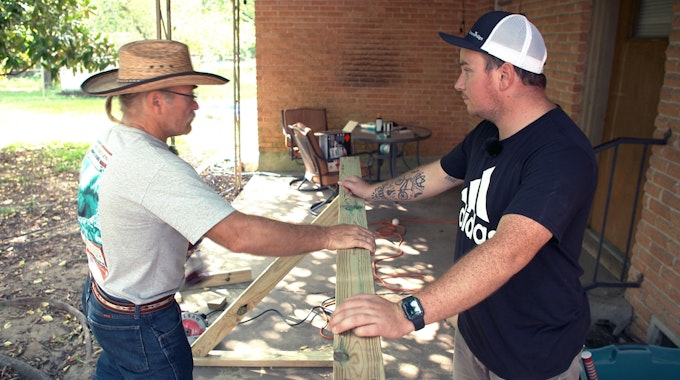 Konny Reimann und Stiefsohn Jason arbeiten mit einem Stück Holz.