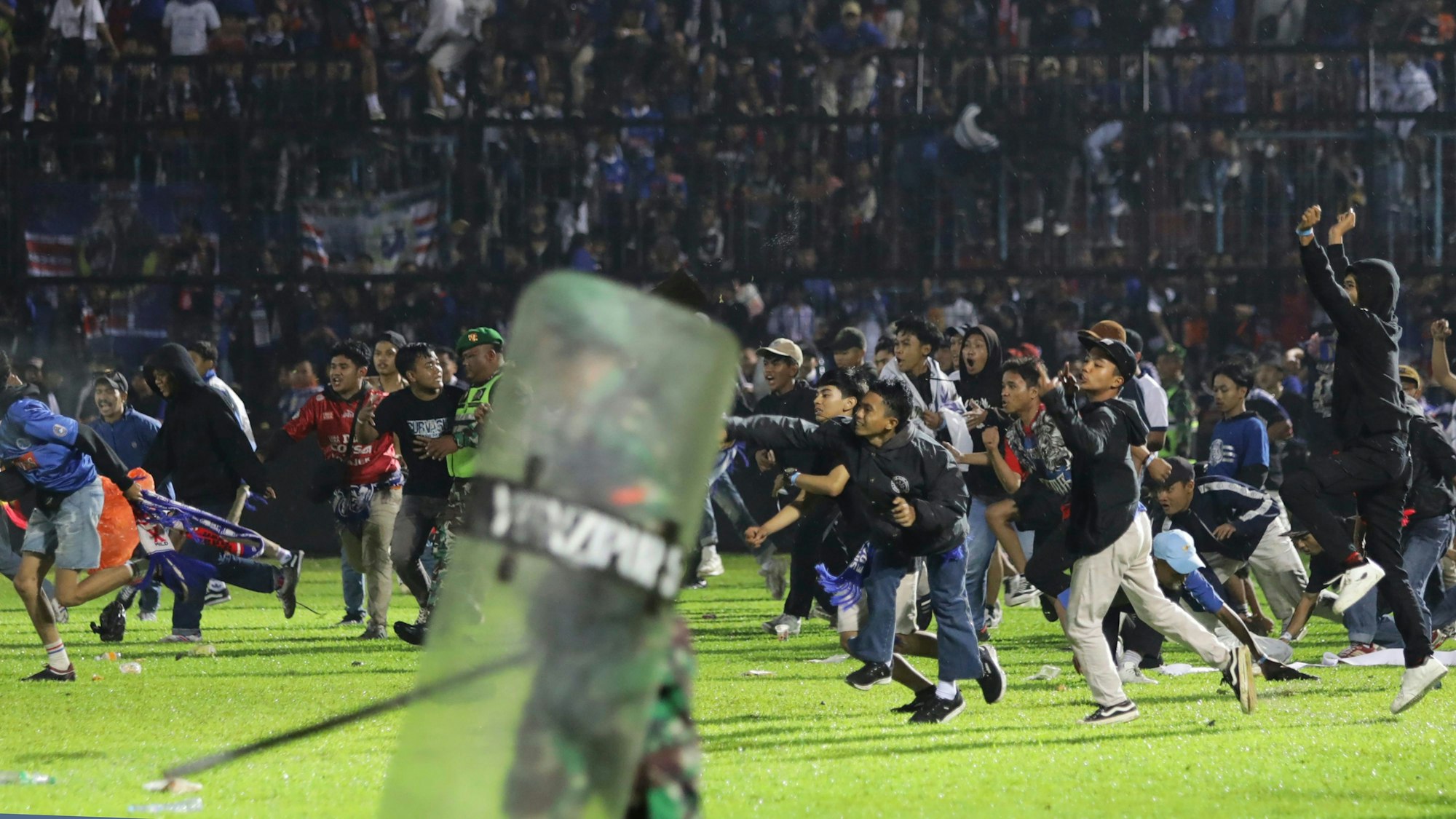 Fans stürmen im Vorlauf der Stadion-Tragödie von Indonesien den Rasen.