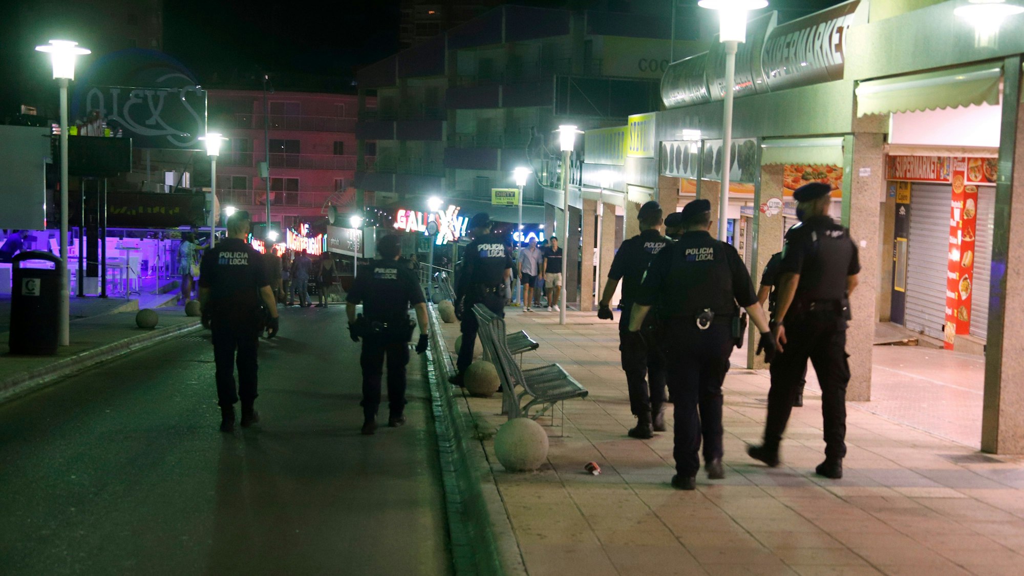 Polizeibeamte patrouillieren nachts auf der Straße Punta Ballena in dem Touristenort Magaluf.