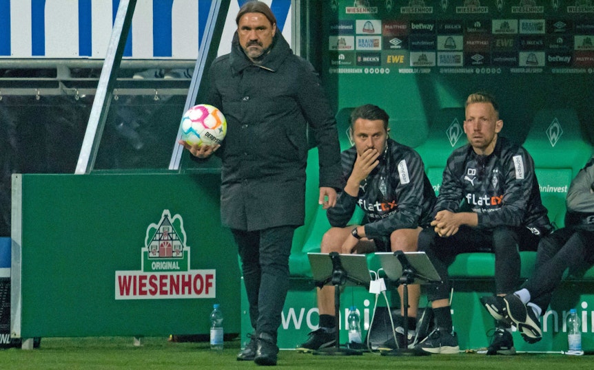Gladbach-Trainer Daniel Farke (l.), hier zu sehen am 1. Oktober 2022 an der Seitenlinie im Bremer Weserstadion. Farke hält einen Ball in seiner rechten Hand.