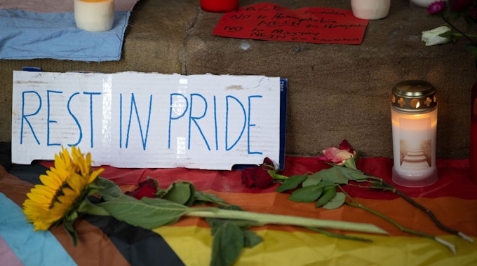 „Rest in Pride“ steht auf einem Karton an der Gedenkstätte für Malte C auf den Stufen des historischen Rathauses am Prinzipalmarkt in Münster.