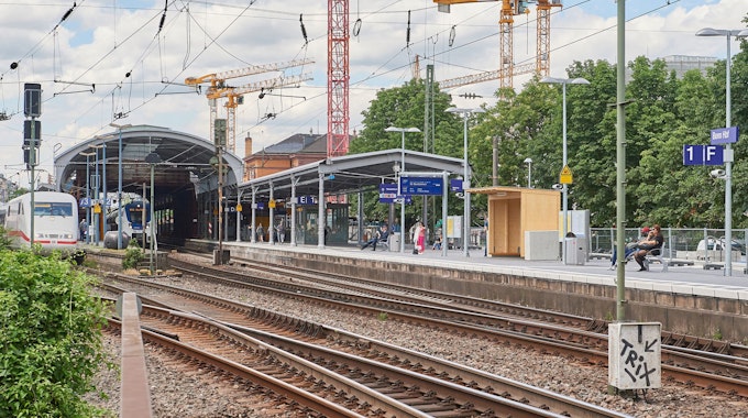 Hinter dem ersten Gleis des Bonner Hauptbahnhofs sind Baukräne zu sehen.