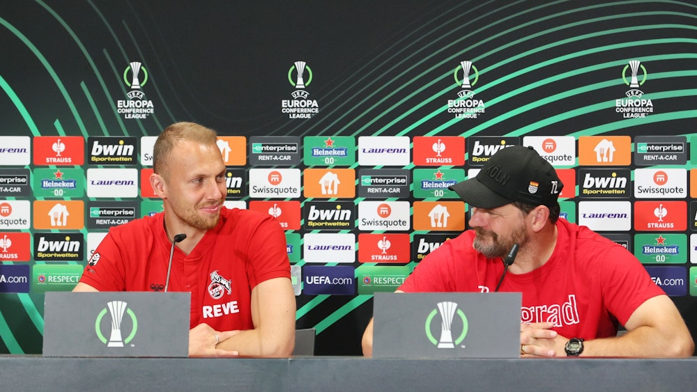 Marvin Schwäbe (links) und Steffen Baumgart lächeln auf der Pressekonferenz des 1. FC Köln am 5. Oktober 2022.