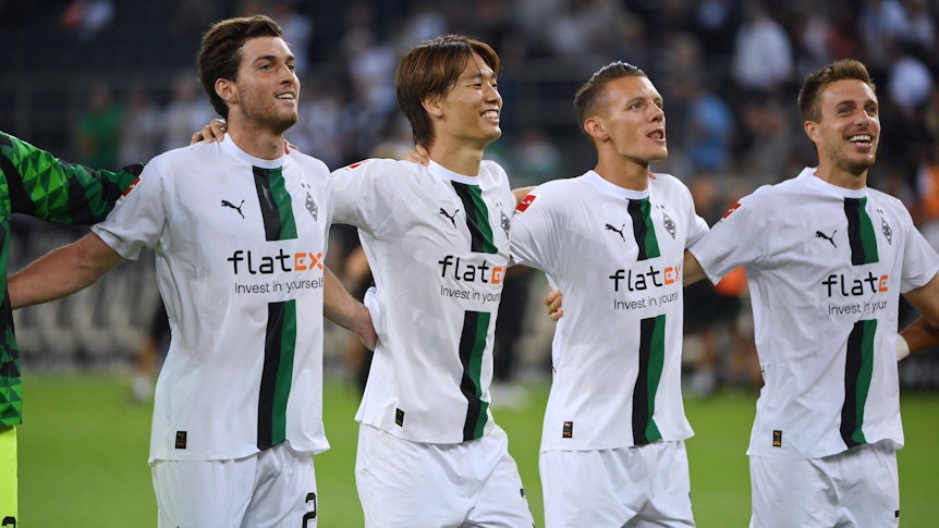 Ko Itakura und Hannes Wolf gemeinsam mit Patrick Herrmann und Joe Scally vor der Nordkurve nach dem Heimsieg gegen Hertha BSC (19. August 2022).