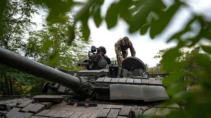 Ukrainische Soldaten stehen auf einem T-80-Panzer, den sie nach eigenen Angaben von der russischen Armee erbeutet haben.&nbsp;