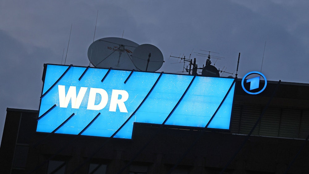 Ein Logo des WDR (Westdeutscher Rundfunk) leuchtet auf dem Dach des Senders.