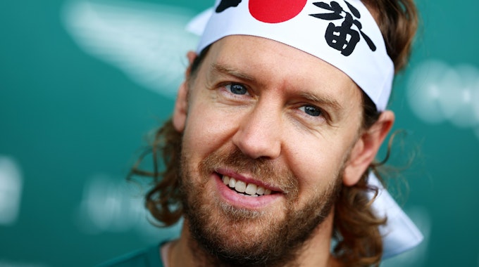 Sebastian Vettel mit Japan-Stirnband auf einer Pressekonferenz.
