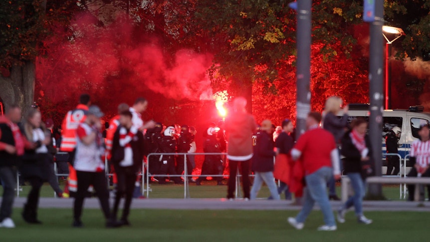 Fans von Partizan Belgrad laufen zum Rhein-Energie-Stadion und zünden Pyrotechnik.