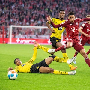 Dan-Axel Zagadou von Borussia Dortmund (M), Jamal Musiala vom FC Bayern München (r.) und Jude Bellingham von Borussia Dortmund (unten) im Kampf um den Ball im Duell Bayern gegen den BVB.