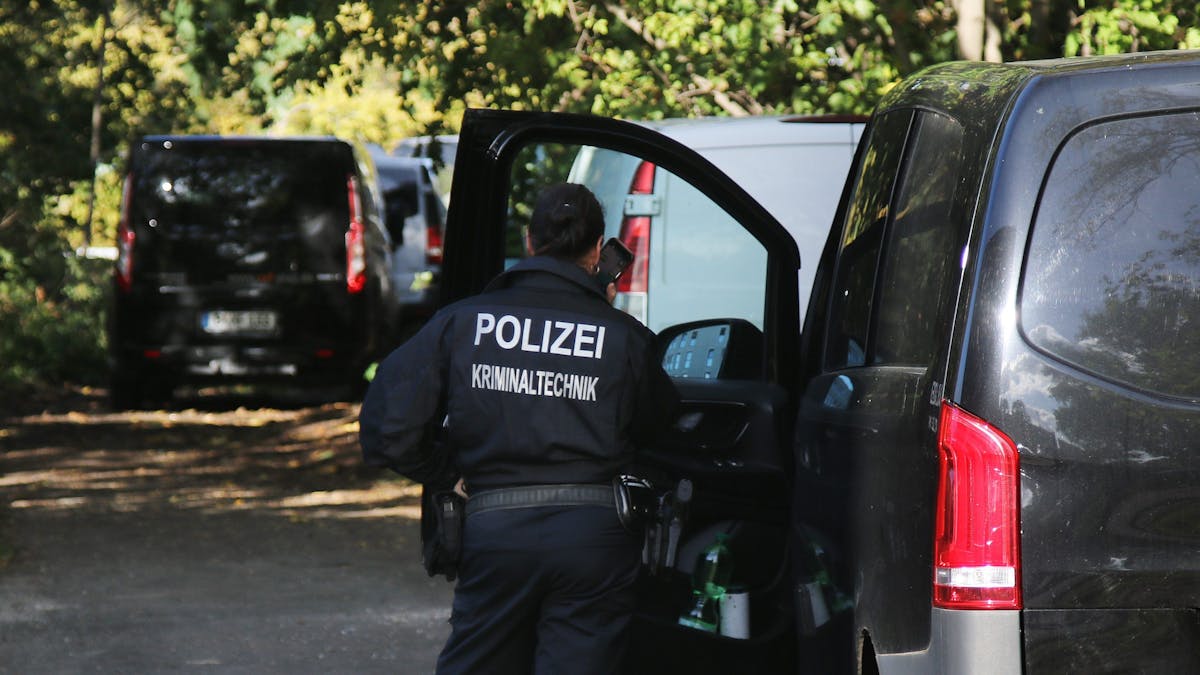 Eine Kriminaltechnikerin steht in der Nähe vom S-Bahnhof Hohenschönhausen neben Fahrzeugen der Polizei. Bislang haben aber weder die Bahn noch die Polizei betätigt, dass der abgebildete Einsatz in Hohenschönhausen im Zusammenhang mit den Sabotageakten steht.