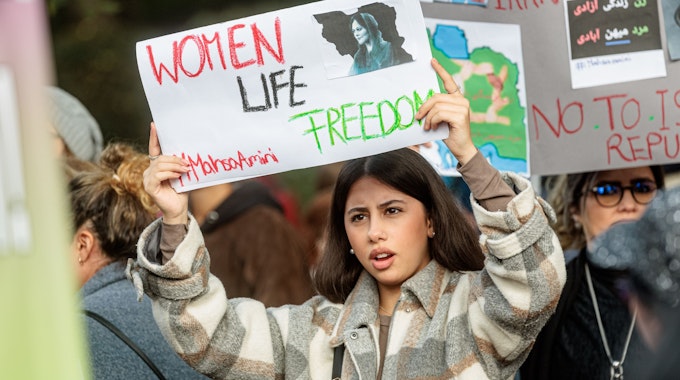 Eine Frau hält ein Schild mit der Aufschrift „Women, Life, Freedom“, dem aktuellen internationalen Slogan gegen das Mullah-Regime in Iran, hoch.